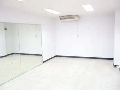 Spacious empty room with mirrored wall and air conditioning unit