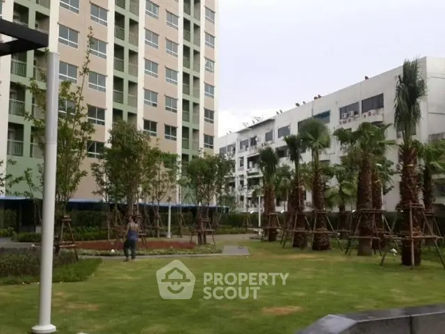 Modern apartment complex with lush garden and palm trees
