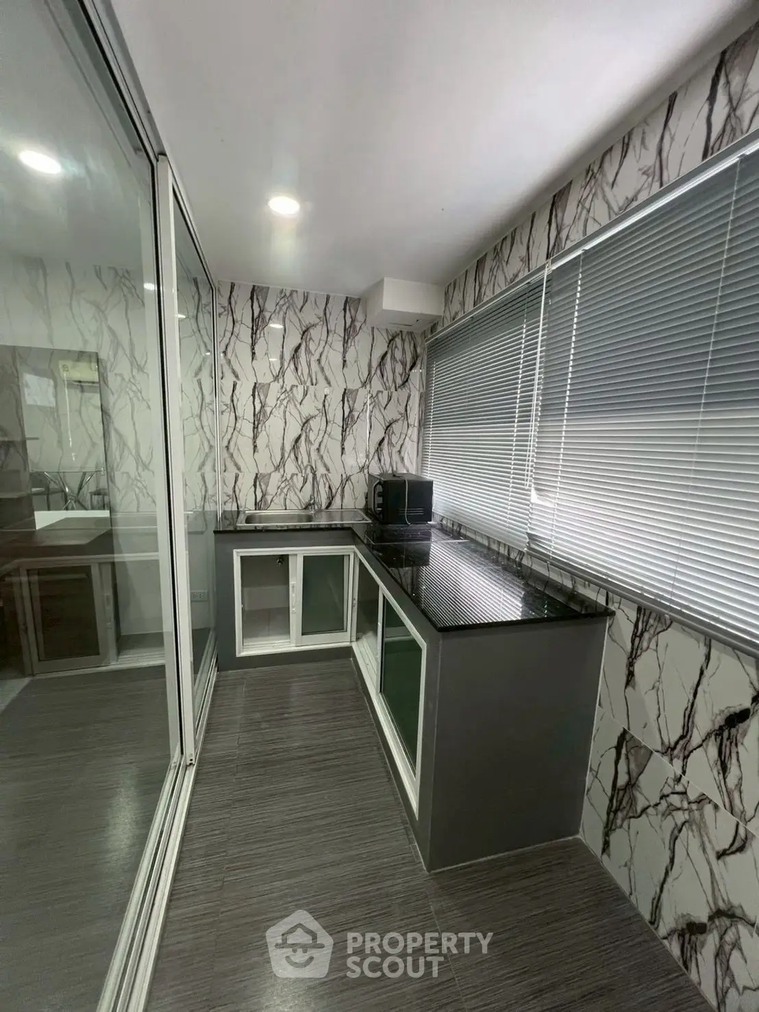Modern kitchen with sleek countertops and marble-patterned walls