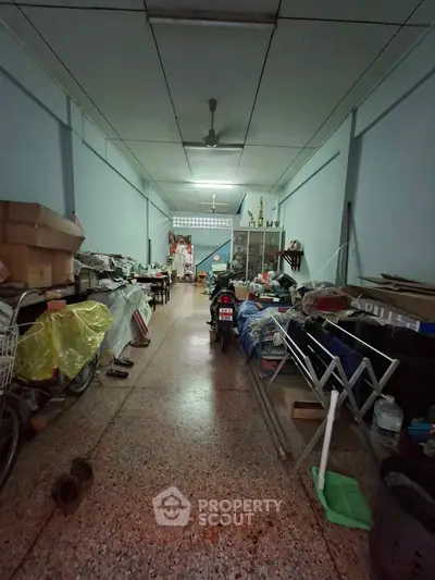 Spacious storage area with various items and a motorcycle, ideal for versatile use.