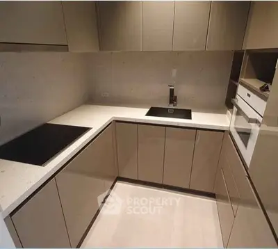 Modern kitchen with sleek cabinetry and built-in appliances in a compact layout.