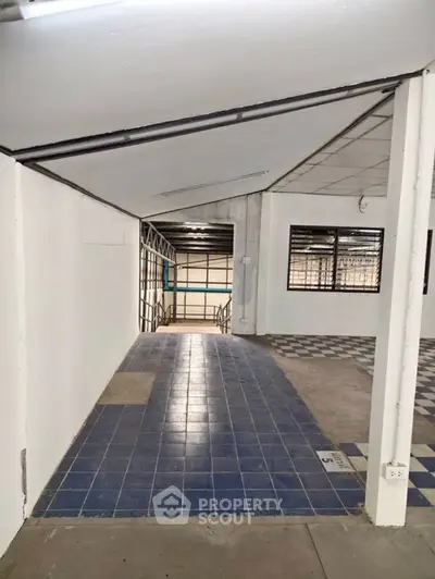 Spacious industrial-style interior with tiled flooring and large windows, ideal for commercial use.