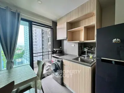 Modern kitchen with balcony view, featuring washing machine and sleek cabinetry in a high-rise apartment.