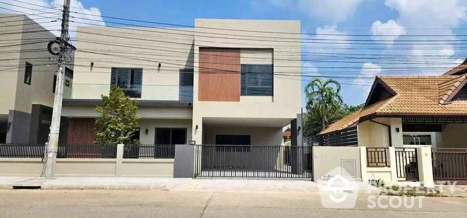 Modern two-story house with sleek design and spacious driveway in a suburban neighborhood.