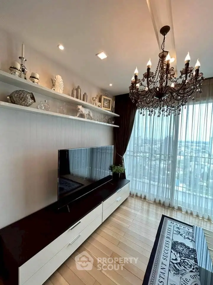 Elegant living room with chandelier and large window offering stunning city views.