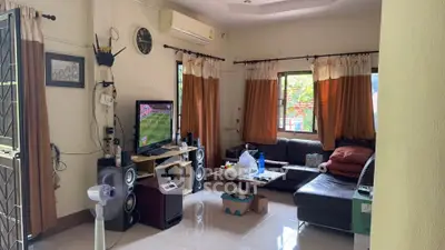 Cozy living room with modern decor, featuring a comfortable sofa, entertainment system, and large windows for natural light.