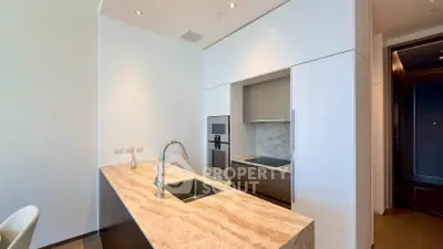 Modern kitchen with sleek design and marble countertop, featuring built-in appliances and stylish fixtures.