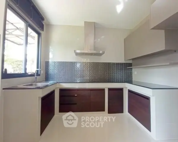 Modern kitchen with sleek cabinetry and stylish backsplash in a bright, airy space.