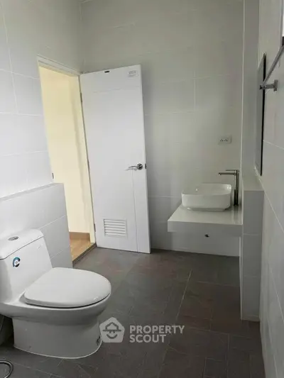 Modern minimalist bathroom with sleek fixtures and neutral tiles.