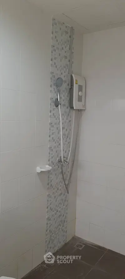 Modern bathroom with tiled shower area and electric water heater