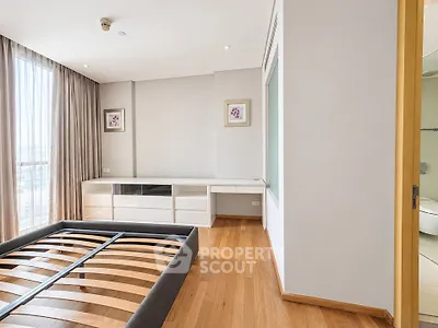 Spacious bedroom with wooden flooring and large window in modern apartment