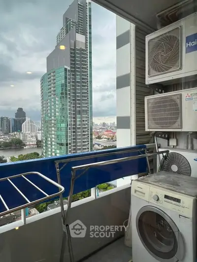High-rise balcony with city view, featuring laundry appliances and modern architecture.