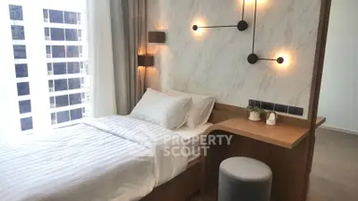 Modern bedroom with stylish lighting and marble accent wall in high-rise apartment