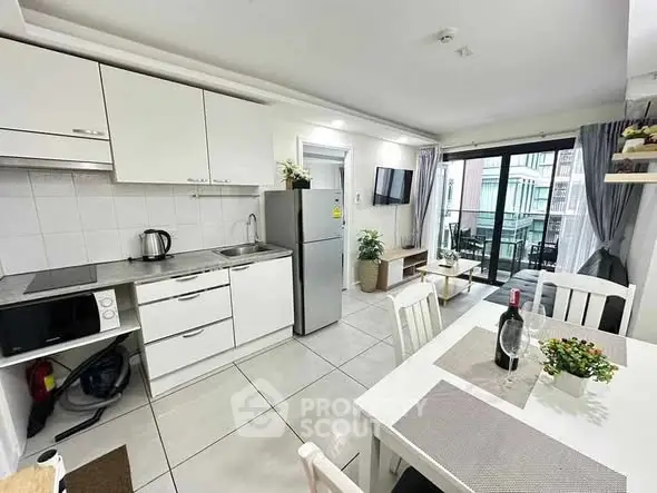 Modern kitchen and dining area with balcony access, featuring sleek appliances and stylish decor.
