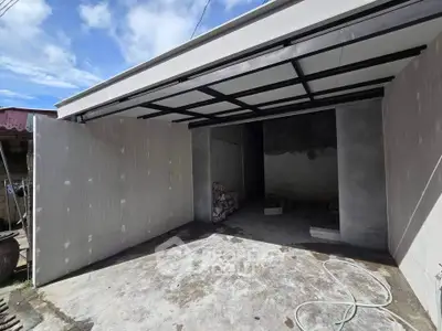 Spacious garage with open door and concrete flooring, perfect for secure parking or storage.