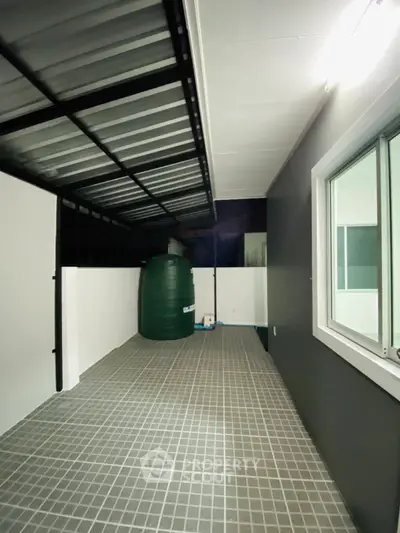 Modern covered outdoor area with tiled flooring and water tank