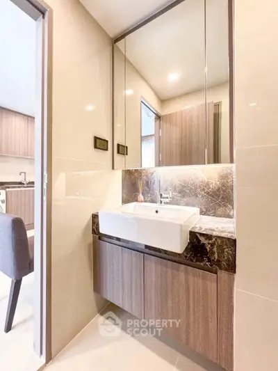 Modern bathroom with sleek vanity and elegant lighting in a contemporary apartment.