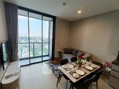 Modern living room with city view and elegant dining setup in high-rise apartment