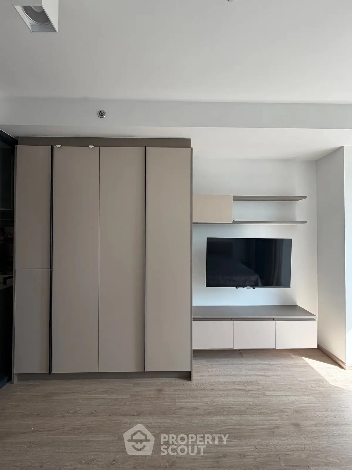 Modern minimalist living room with sleek cabinetry and mounted TV