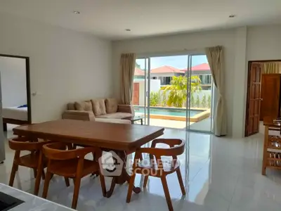 Spacious living room with pool view and elegant wooden furniture