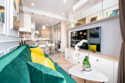 Modern living room with vibrant green sofa, open kitchen layout, and stylish decor.