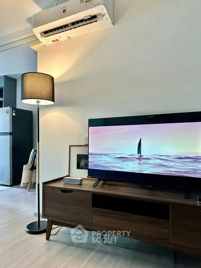 Modern living room with sleek TV setup and stylish floor lamp, perfect for cozy evenings.