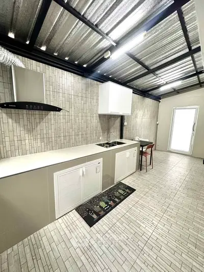 Modern kitchen with sleek design and open layout, featuring stainless steel appliances and tiled flooring.