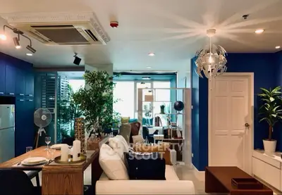 Modern living room with stylish decor, blue accents, and open layout in a high-rise apartment.