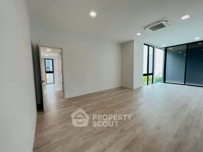 Spacious modern living room with large windows and wood flooring