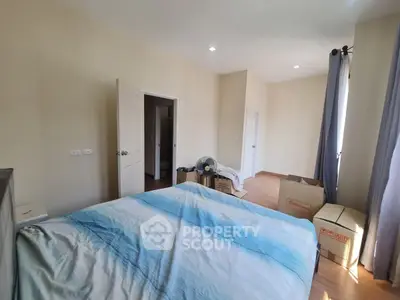 Spacious bedroom with natural light and moving boxes, ideal for new beginnings.