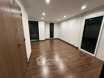 Spacious modern living room with wooden flooring and large windows