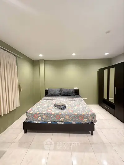 Spacious bedroom with modern decor and large bed in a serene setting.