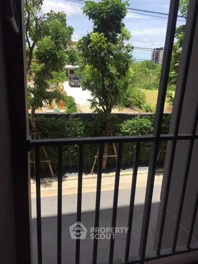 Charming garden view from a balcony with lush greenery and serene surroundings.
