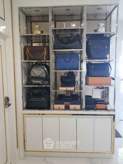 Luxurious storage display with designer handbags in elegant shelving unit.