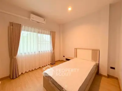 Spacious bedroom with natural light and modern furnishings