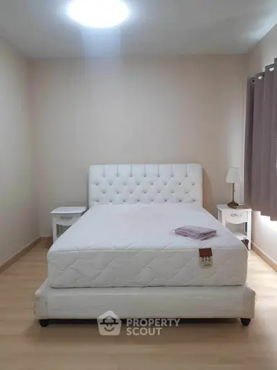 Spacious bedroom with elegant white bed and side tables, perfect for a serene retreat.