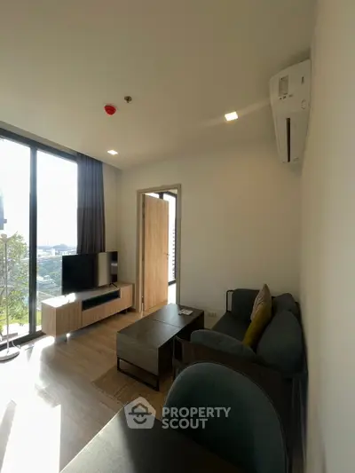Modern living room with large windows and stylish furniture, offering a bright and inviting atmosphere.
