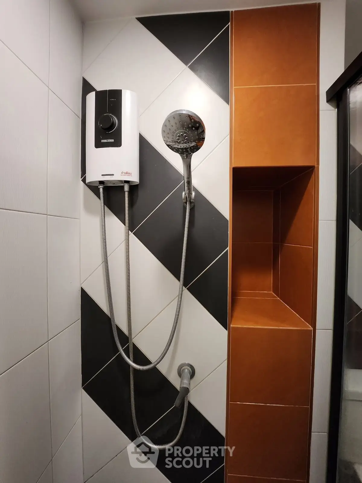 Modern bathroom with stylish shower and water heater, featuring sleek black and white tiles.