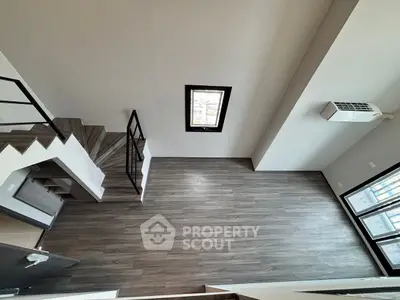 Modern loft-style living room with high ceiling and wooden flooring