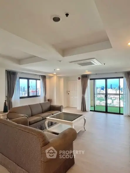 Spacious living room with city view and elegant furnishings in modern apartment.