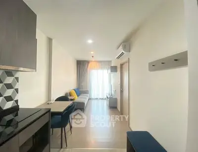 Modern living room with stylish decor and natural light, featuring a cozy sofa and dining area.