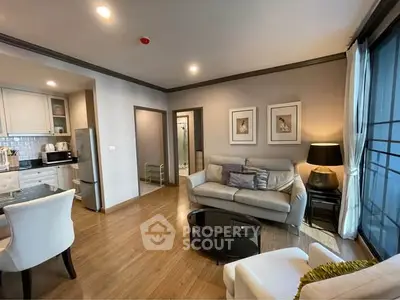 Modern living room with open kitchen and stylish decor in a cozy apartment.