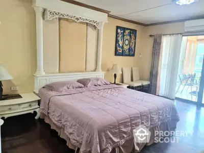 Elegant master bedroom with a large bed, ornate headboard, and access to a sunlit balcony, perfect for luxurious living.