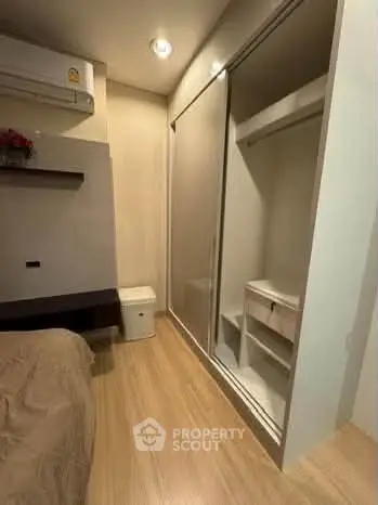 Cozy bedroom with built-in wardrobe and modern air conditioning unit.