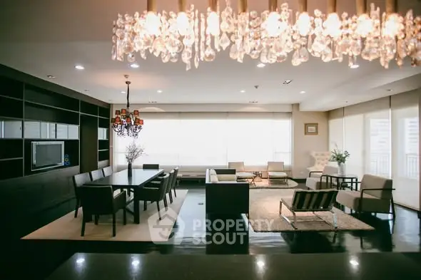 Luxurious open-layout living room with elegant chandelier and modern furniture.