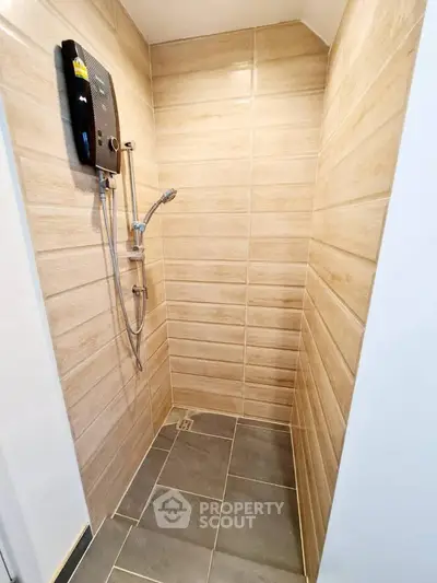 Modern bathroom shower area with sleek tile design and water heater.