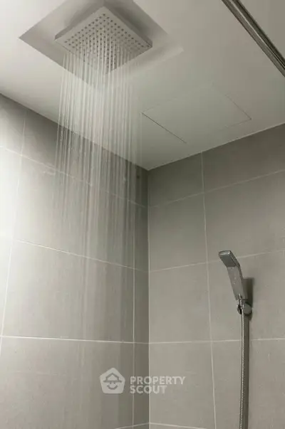 Modern bathroom with ceiling rain shower and sleek tile design