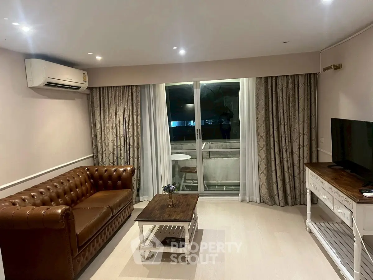 Stylish living room with leather sofa and balcony access in modern apartment.
