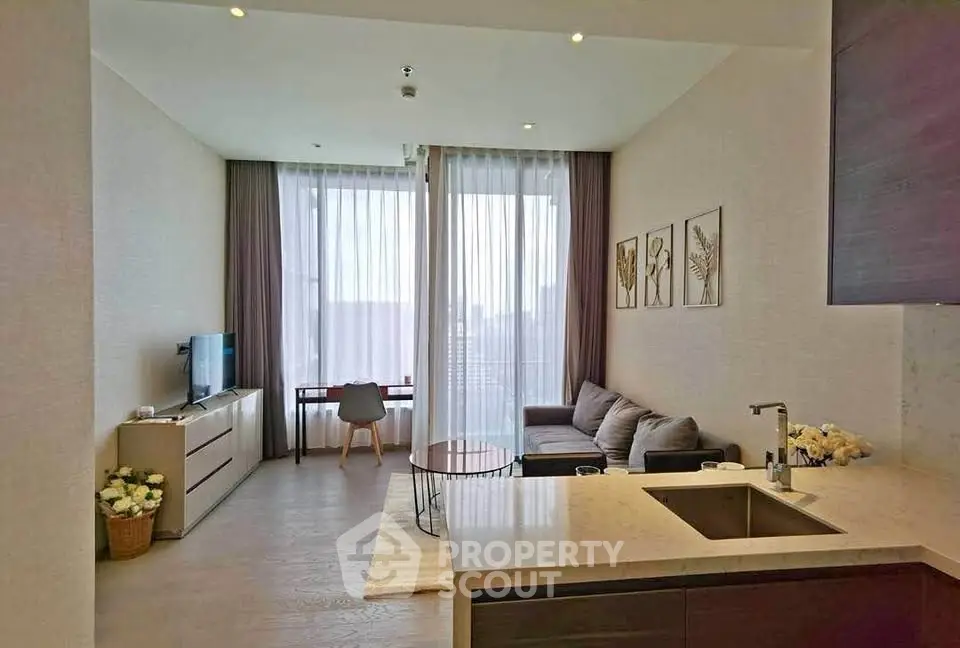 Modern living room with open kitchen and city view, featuring stylish decor and natural light.
