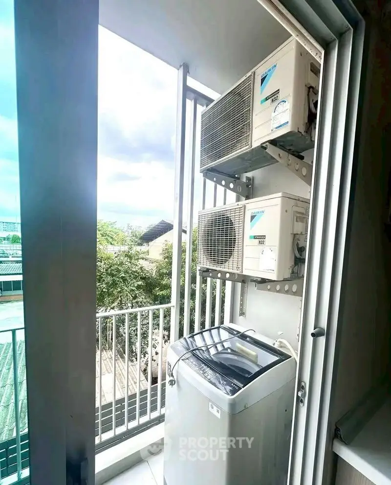 Compact balcony with washing machine and air conditioning units, ideal for urban living.